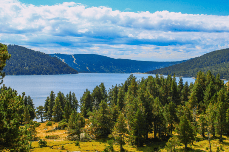 Le randonneur longe le lac des Bouillouses sur le GRP Tour du Capcir.